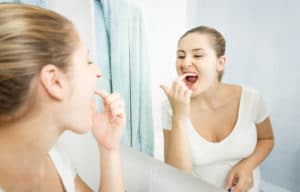 female patient examining teeth in mirror