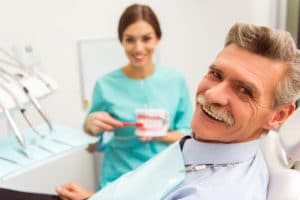 woman explaining restorative dentistry to male patient