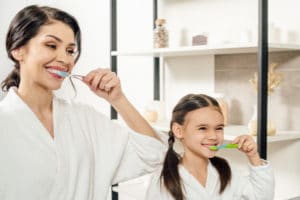 mom and daughter brushing teeth