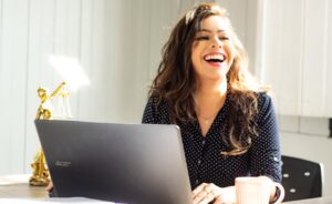 woman smiling at computer after periodontal Austin, TX visit