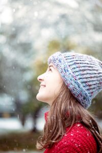 A young woman smiles widely after following cold-weather oral hygiene tips