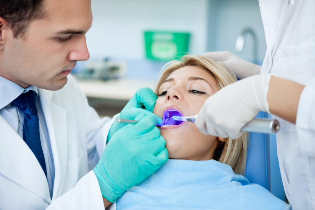 patient with open mouth receiving dental filling drying procedure.