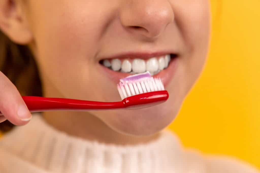 girl brushing her teeth to maintain teeth whitening treatment