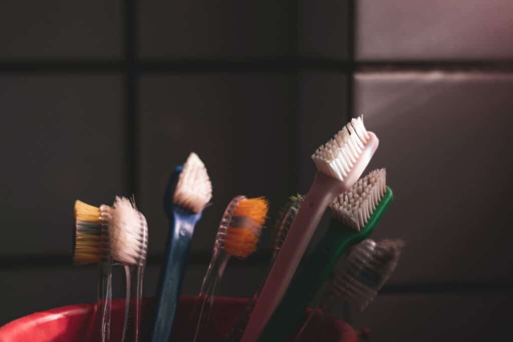 different colored toothbrushes standing upright in a cup