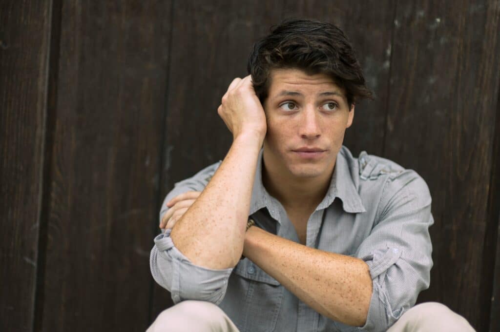 Young man sitting with his head in his hand