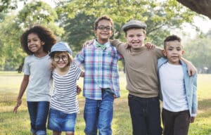 five children posing for a picture in a park