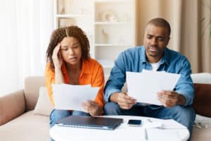 couple looking disappointed at dental bills